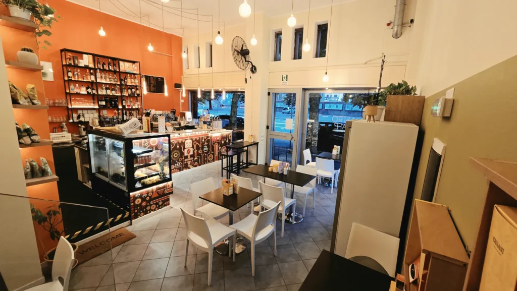 Tavolini e sedie bianche nella sala di Astro Cafè